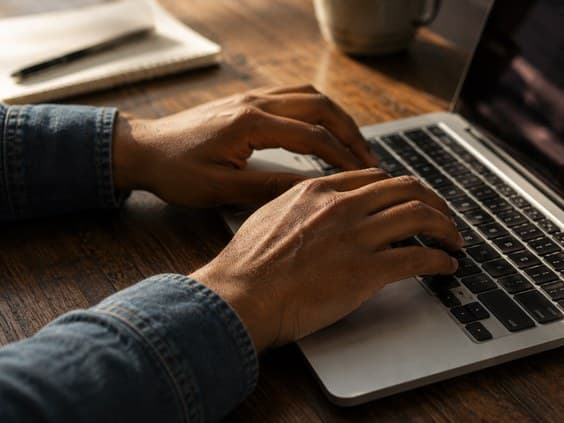 Hands typing on a laptop keyboard